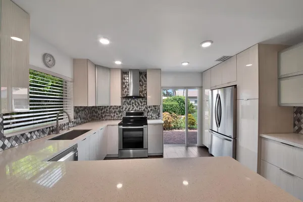 a kitchen with stainless steel appliances a refrigerator sink and stove