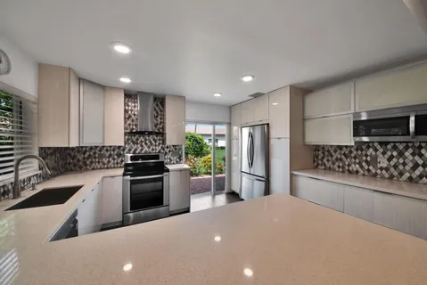 a kitchen with stainless steel appliances a refrigerator sink and stove