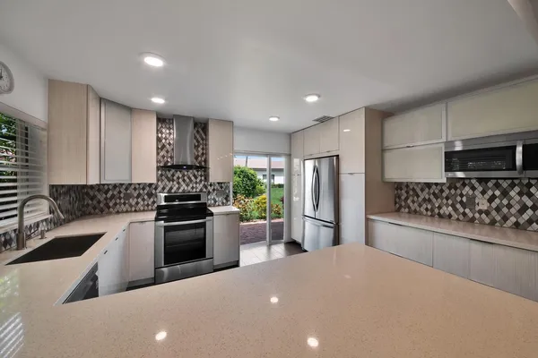 a kitchen with stainless steel appliances a refrigerator sink and stove