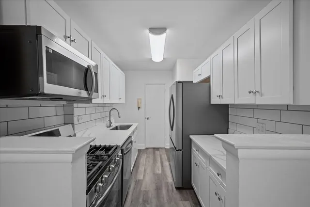a kitchen with a sink cabinets and stainless steel appliances