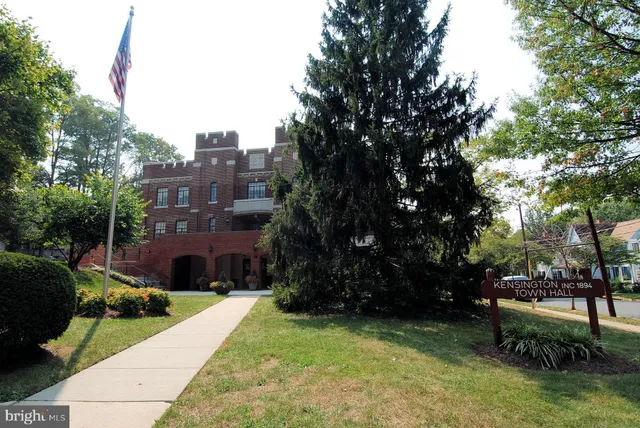 a view of street sign under a large tree