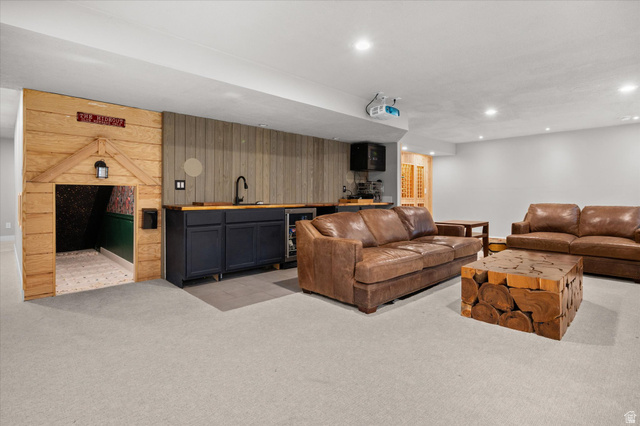 3359 Eurasian Crane Road Clinton, UT 84015 - Photo 37 of 71 Living room with light carpet, beverage cooler, wet bar, wood walls, and recessed lighting