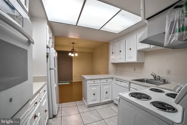 a kitchen that has a sink a stove and cabinets