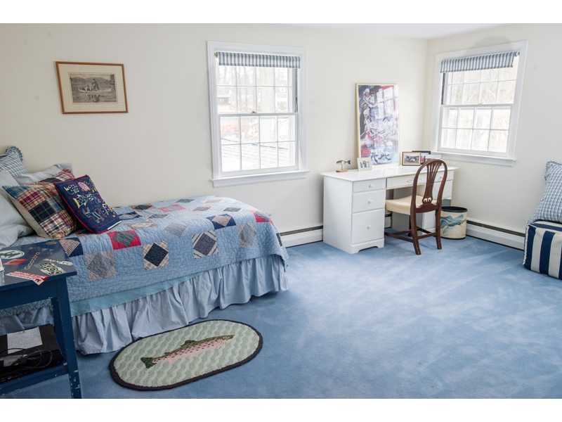 201 Michigan Road New Canaan, CT 06840 - Photo 17 of 25 a bedroom with a bed a chandelier a mirror on dresser and a window