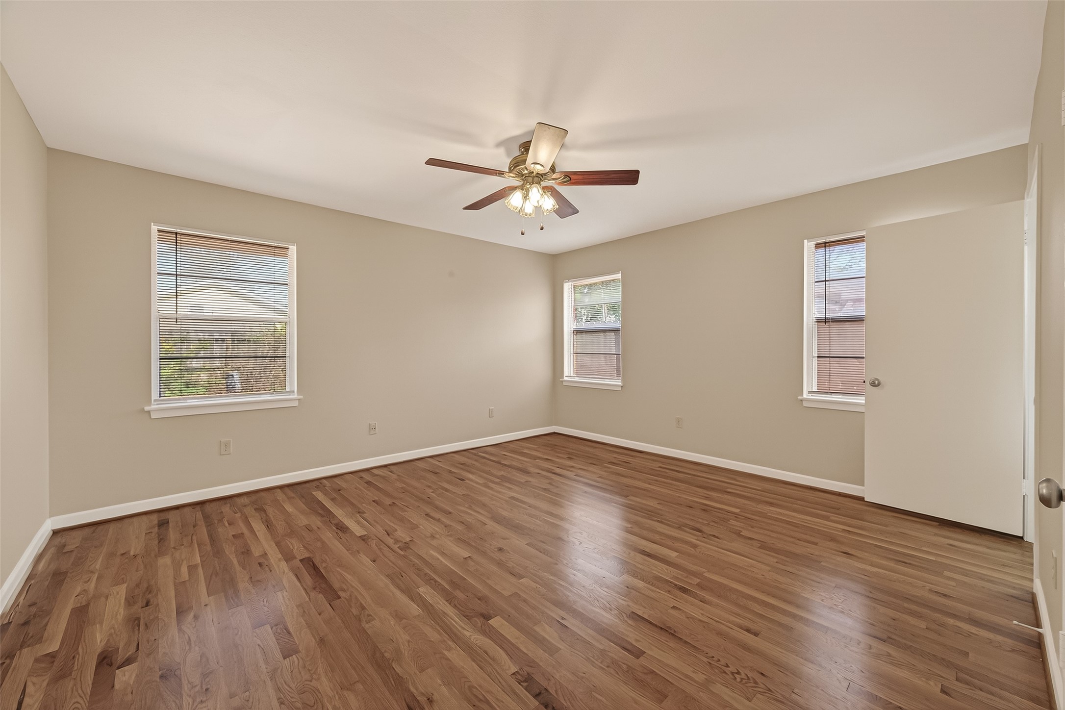 5646 Hazen Street Houston, TX 77081 - Photo 21 of 43 The spacious primary has hardwood floors and bright windows, providing plenty of natural light.