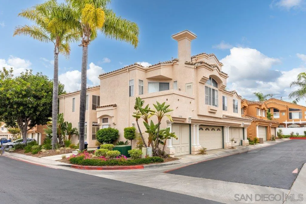 a front view of a house with a yard and potted plants