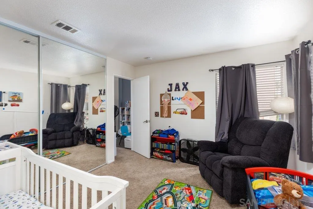 1352 Serena Circle, Unit 2 Chula Vista, CA 91910 - Photo 21 of 22 a living room with furniture and a baby crib