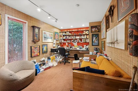a living room with furniture a flat screen tv and a floor to ceiling window