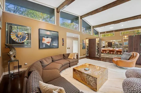 a living room with furniture a rug and a large window