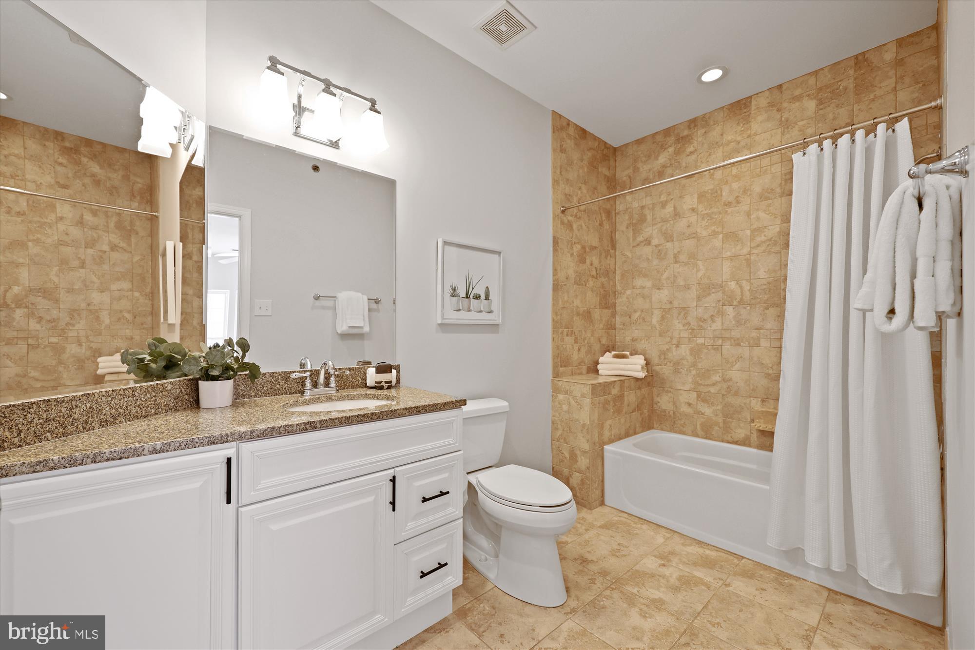 106 Booth Street, Unit 34 Gaithersburg, MD 20878 - Photo 18 of 46 a bathroom with a granite countertop sink a toilet a mirror and shower