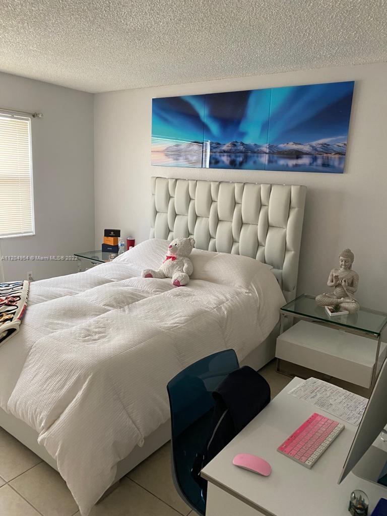 17901 Northwest 68th Avenue, Unit T207 Hialeah, FL 33015 - Photo 11 of 19 a bedroom with a bed and window