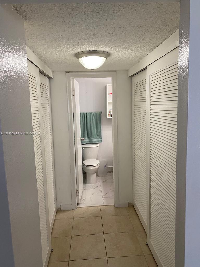 17901 Northwest 68th Avenue, Unit T207 Hialeah, FL 33015 - Photo 15 of 19 a bathroom with a glass door and shower