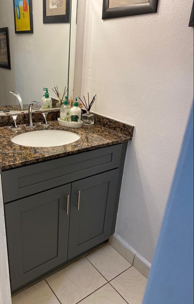 17901 Northwest 68th Avenue, Unit T207 Hialeah, FL 33015 - Photo 16 of 19 a bathroom with a granite countertop sink and a mirror