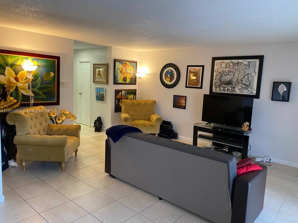 17901 Northwest 68th Avenue, Unit T207 Hialeah, FL 33015 - Photo 2 of 19 a living room with furniture and a flat screen tv