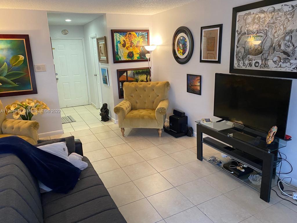 17901 Northwest 68th Avenue, Unit T207 Hialeah, FL 33015 - Photo 4 of 19 a living room with furniture and a flat screen tv