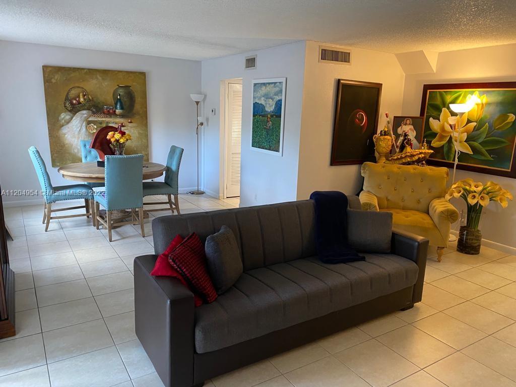 17901 Northwest 68th Avenue, Unit T207 Hialeah, FL 33015 - Photo 5 of 19 a living room with furniture and a flat screen tv