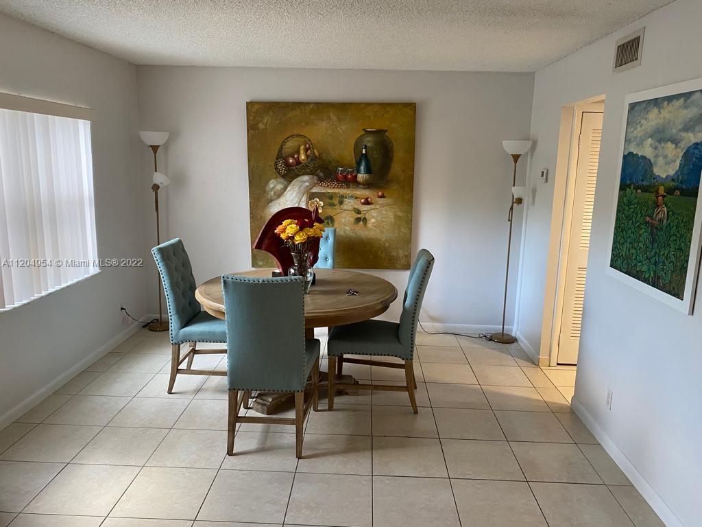 17901 Northwest 68th Avenue, Unit T207 Hialeah, FL 33015 - Photo 6 of 19 a view of a dining room with furniture and a window