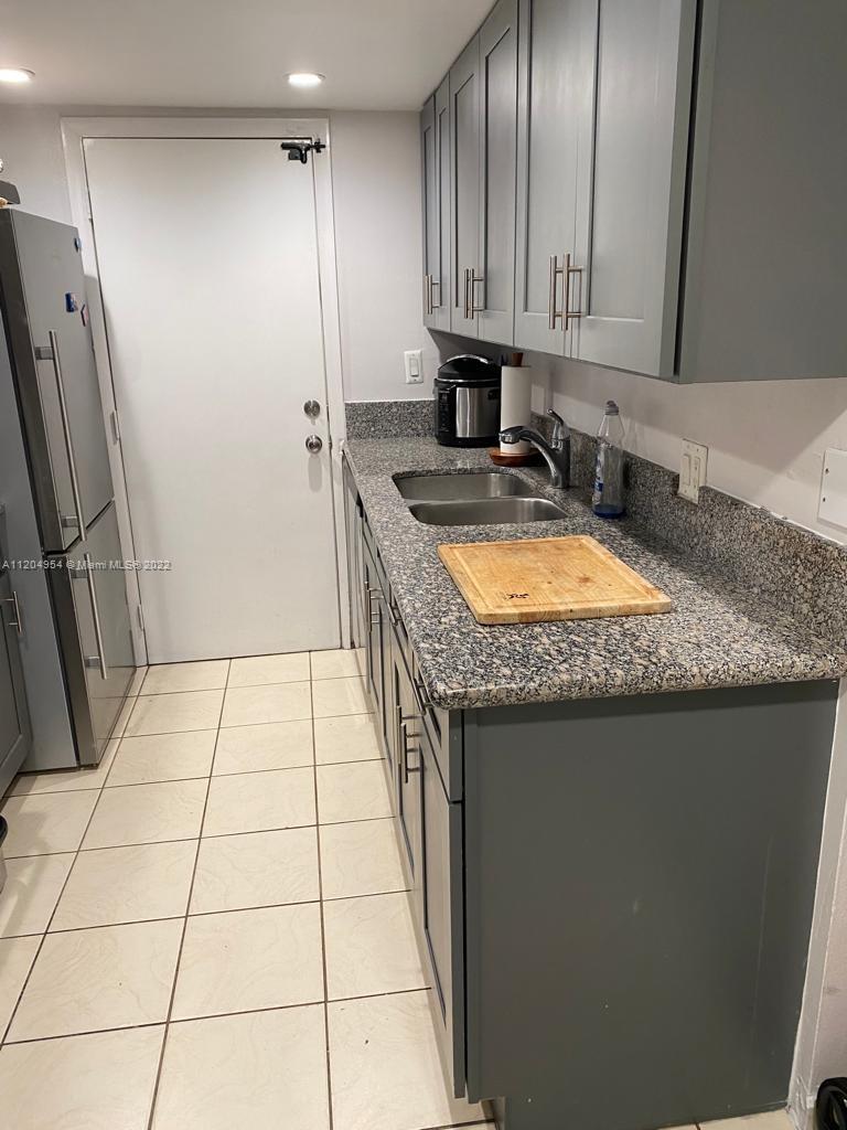17901 Northwest 68th Avenue, Unit T207 Hialeah, FL 33015 - Photo 8 of 19 a kitchen with granite countertop a sink stove and refrigerator