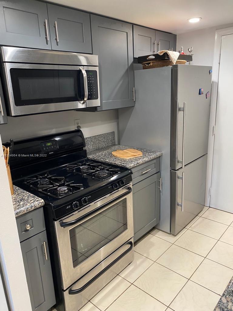 17901 Northwest 68th Avenue, Unit T207 Hialeah, FL 33015 - Photo 9 of 19 a kitchen with granite countertop a stove microwave and refrigerator