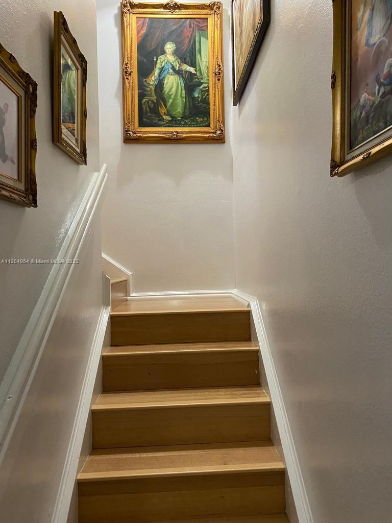 17901 Northwest 68th Avenue, Unit T207 Hialeah, FL 33015 - Photo 10 of 19 a view of staircase with wooden floor and a rug