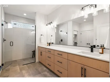 a bathroom with a double vanity sink mirror and shower