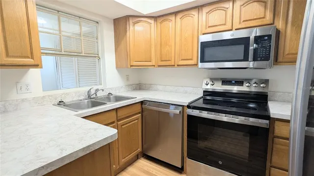 a kitchen with stainless steel appliances granite countertop a sink stove and microwave