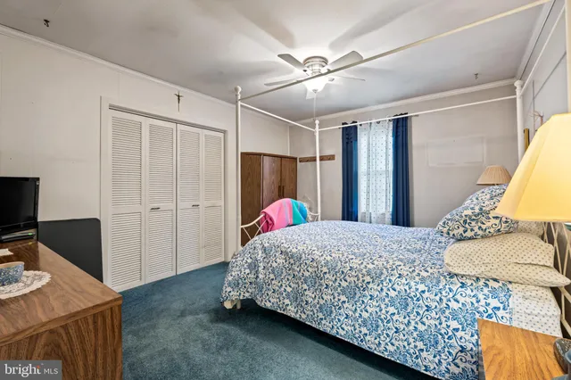 a living room with a bed furniture and a flat screen tv