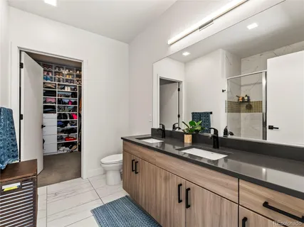 a bathroom with a granite countertop sink a toilet and shower