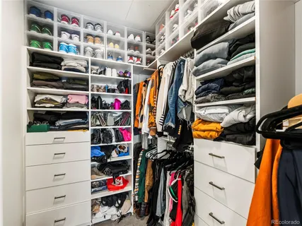 a view of walk in closet with clothes and shoes