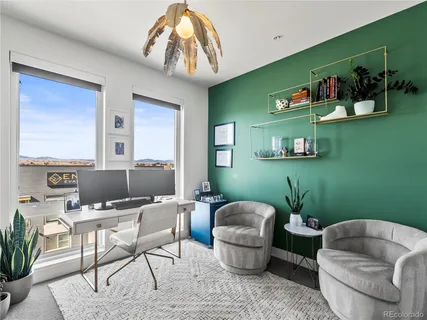 a living room with furniture and a painting on the wall