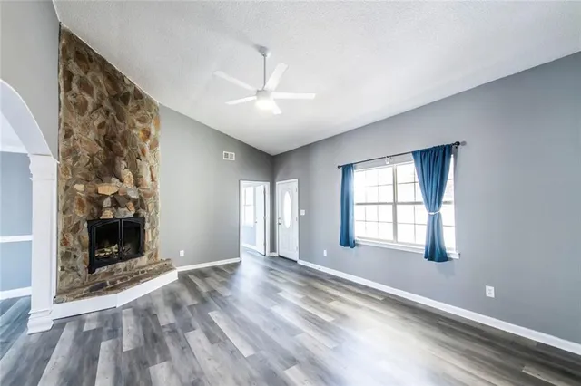 an empty room with windows and fireplace