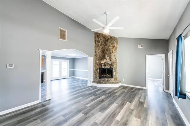 a view of a room with wooden floor fireplace and windows