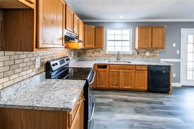 a kitchen with a stove a sink a refrigerator and wooden cabinets
