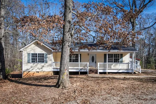 a front view of a house with a yard and potted plants