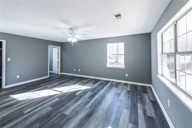 a view of empty room with window and wooden floor