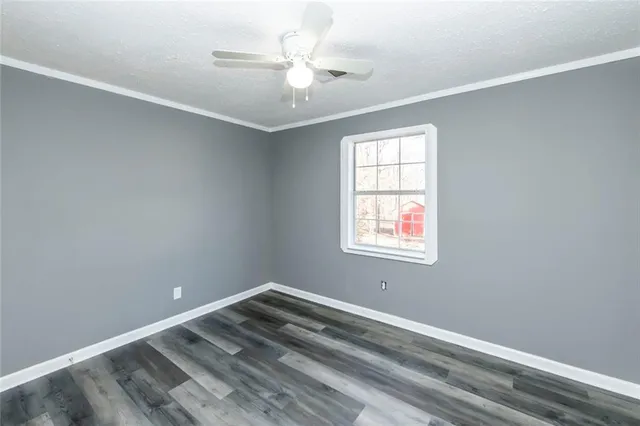 an empty room with a window and a ceiling fan
