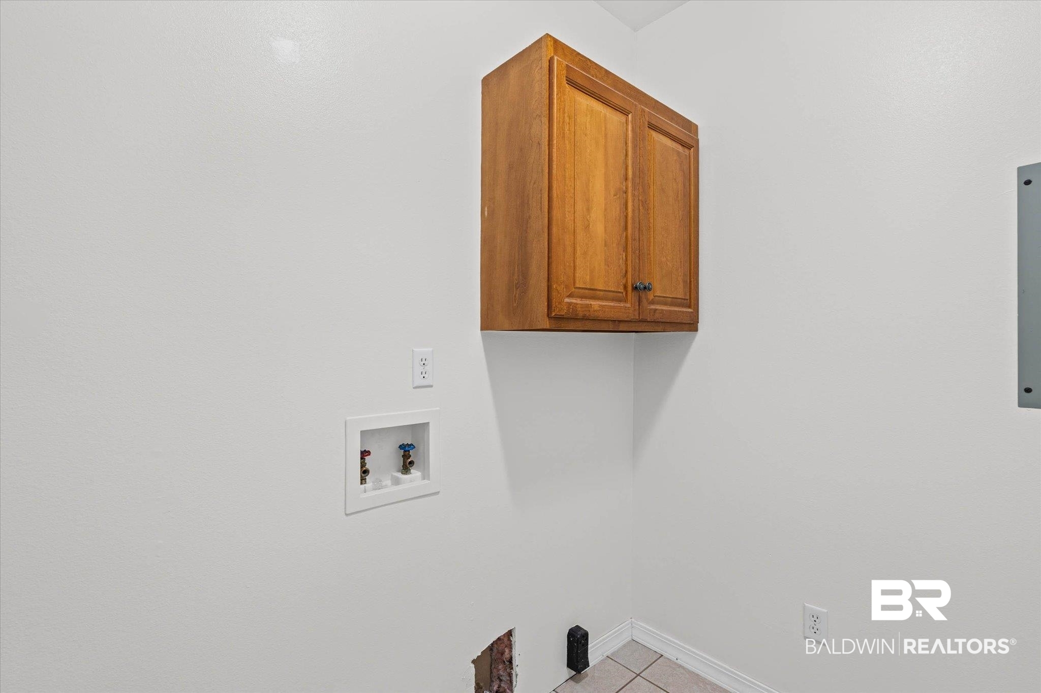 41923 Bayou Road Bay Minette, AL 36507 - Photo 22 of 35 Laundry area featuring a wall-mounted wood-finish cabinet, white painted walls, tile flooring, and utility hookups