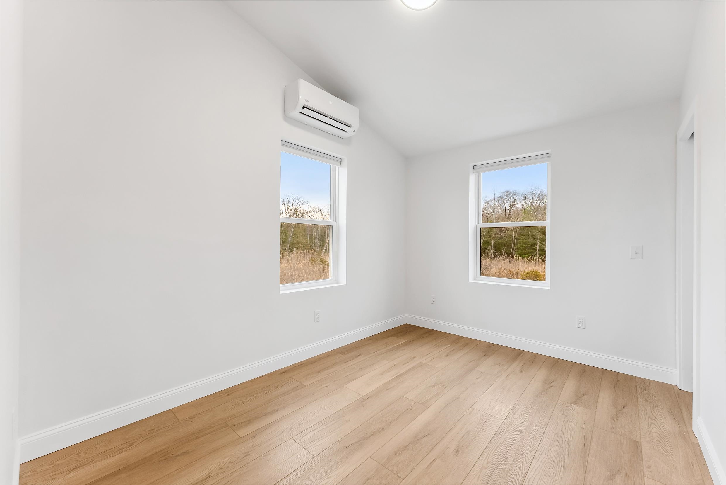 22 Moores Beach Road Delmont, NJ 08314 - Photo 7 of 18 an empty room with wooden floor and windows