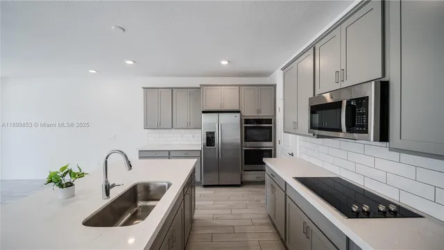 a kitchen with granite countertop stainless steel appliances and a sink