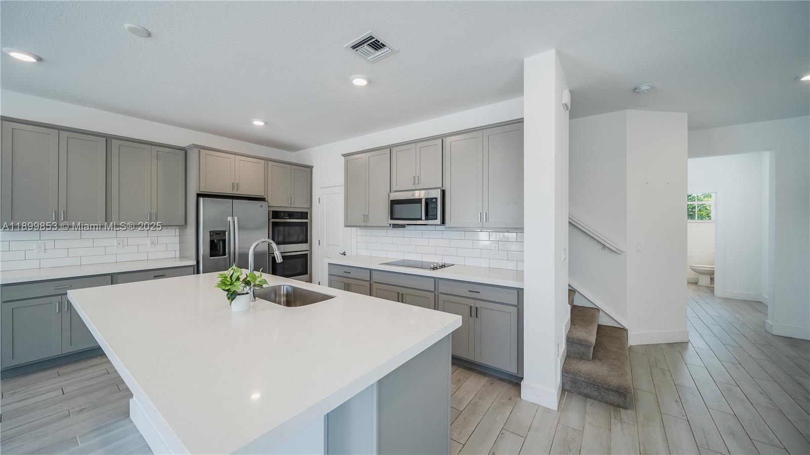 241 Preserve Trail North Stuart, FL 34994 - Photo 12 of 37 a kitchen with stainless steel appliances a stove a sink cabinets and a wooden floor