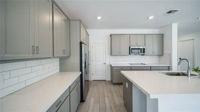 a kitchen with a sink a stove a refrigerator and cabinets