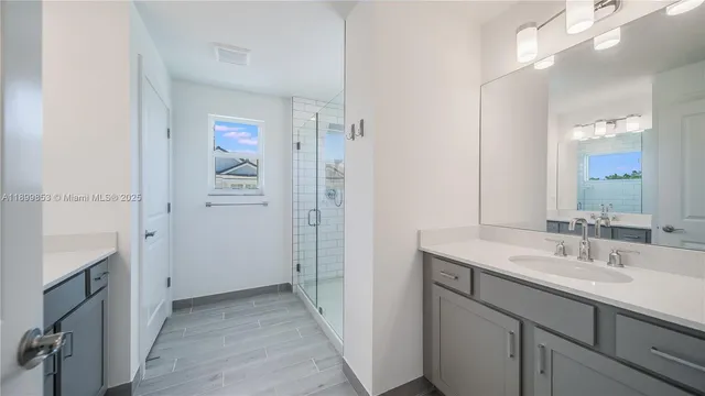 a bathroom with a sink a mirror and a shower