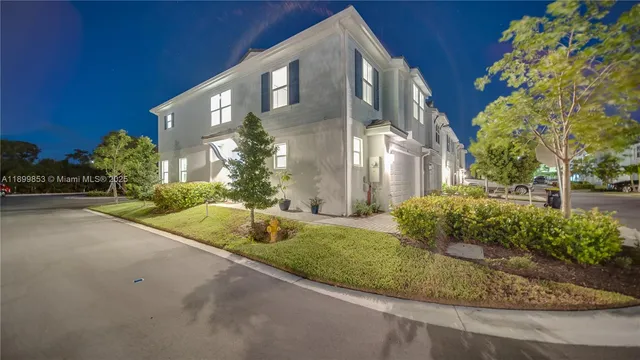 a view of a house with a yard and pathway