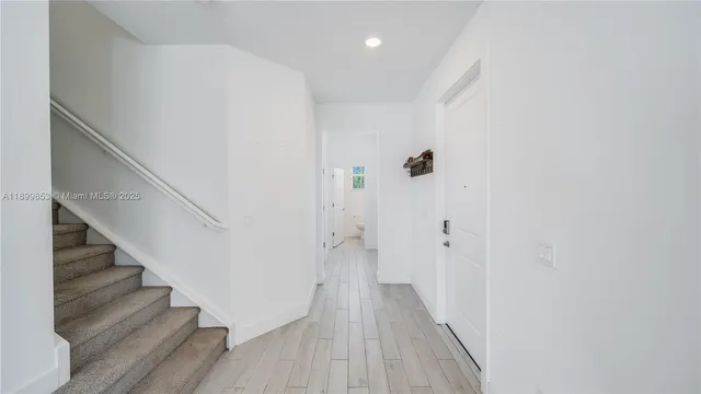 a view of a hallway with wooden floor and entryway