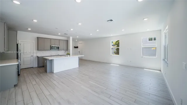 a large kitchen with stainless steel appliances kitchen island a large counter top and a stove top oven