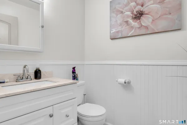 a bathroom with a sink a toilet and a mirror