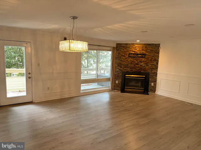 an empty room with windows and fireplace