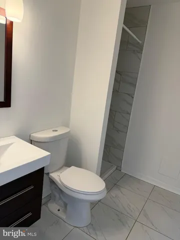 a white toilet sitting next to a white sink and vanity