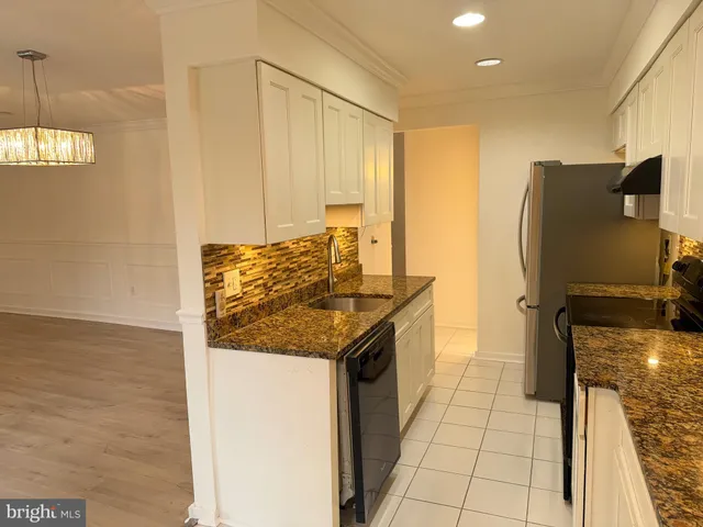 a kitchen with granite countertop a refrigerator and a stove