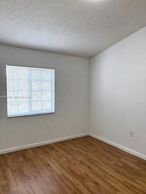 14045 Southwest 121st Place, Unit 524 Miami, FL 33186 - Photo 30 of 46 a view of an empty room with wooden floor and a window